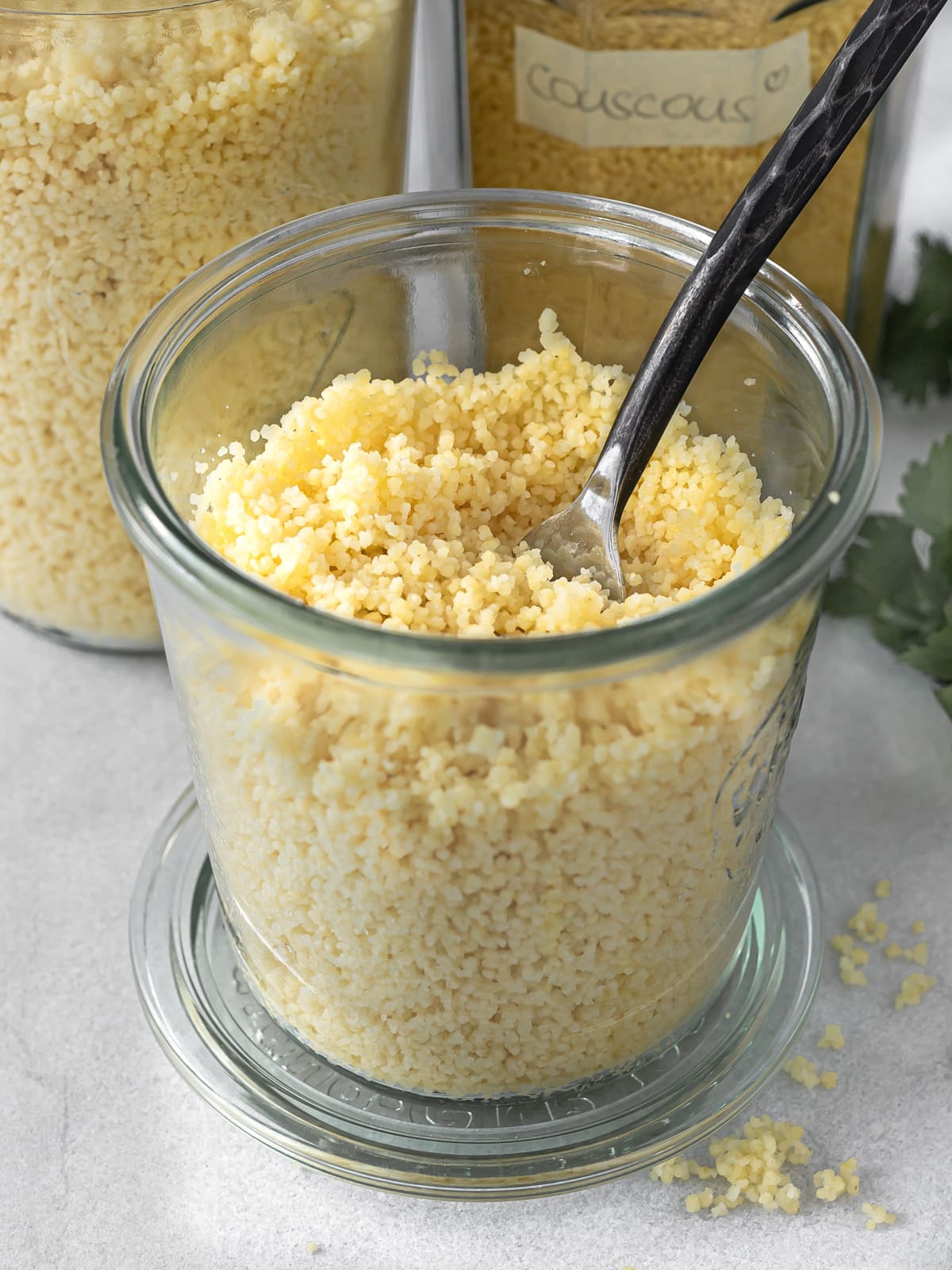 Jar of cooked couscous with a fork.