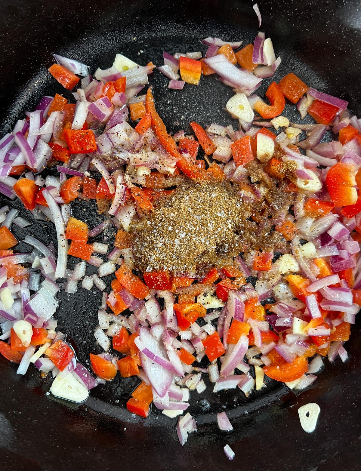 Veggies in Mexican spices in a cast iron pan.