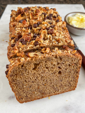 Vegan banana bread loaf with a slice cut off.