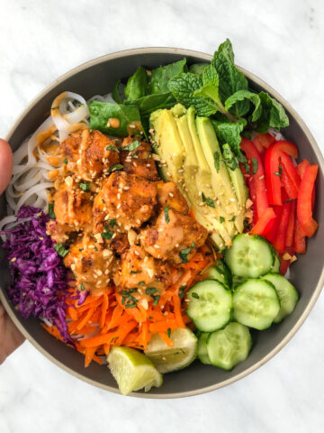 Tofu and vegetable rice bowl smothered in peanut sauce.