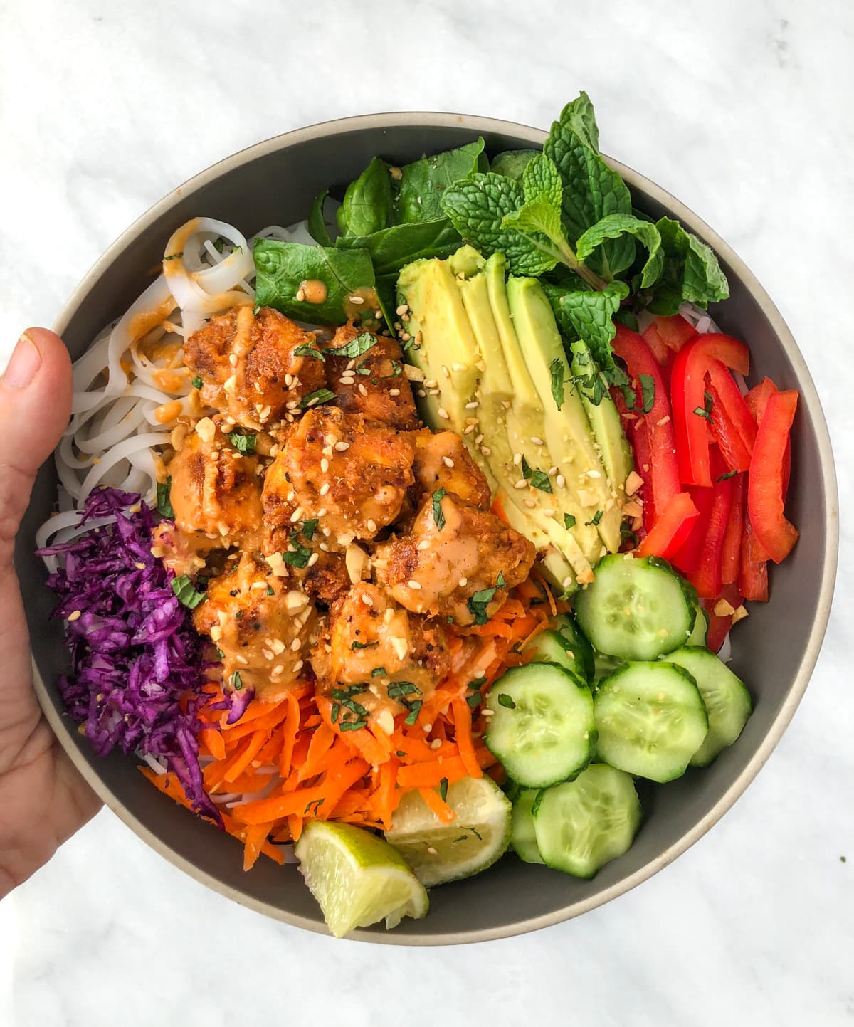 Tofu and vegetable rice bowl smothered in peanut sauce.