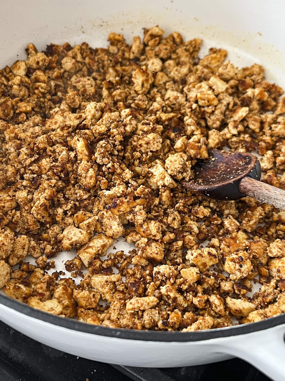 Pan frying seasoned tofu crumbles to make high protein vegan tofu tacos.